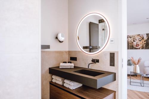 a bathroom with a sink and a mirror at VISAMA, moderne Apartments an der Fulda-Aue in Fulda