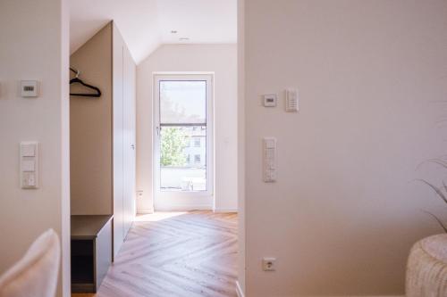 an empty room with a window and a hallway at VISAMA, moderne Apartments an der Fulda-Aue in Fulda
