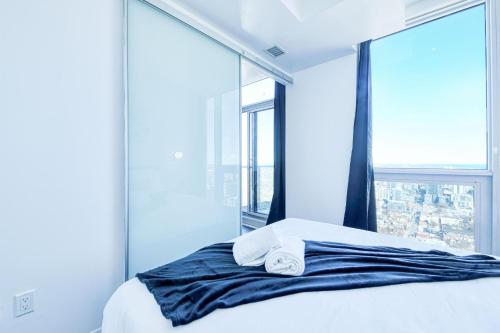 a bedroom with a bed with a large window at RivetStays - The Jarvis in Toronto