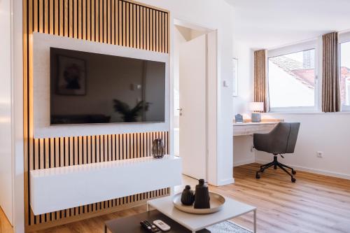 a living room with a large television on a wall at VISAMA, moderne Apartments an der Fulda-Aue in Fulda