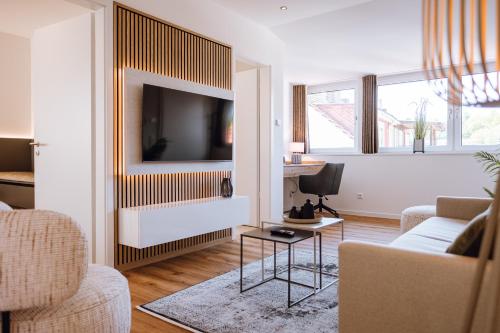 a living room with a tv on a wall at VISAMA, moderne Apartments an der Fulda-Aue in Fulda