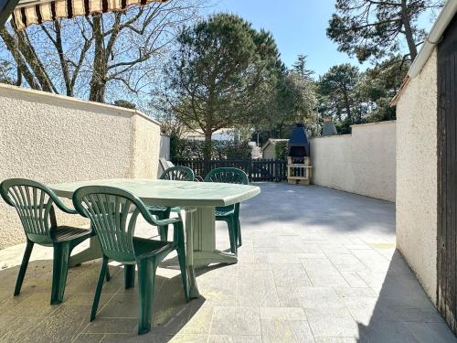 une table et des chaises assises sur une terrasse dans l'établissement Maison plage à 900m, 3 chambres, terrasse, barbecue, parking, proximité commerces, calme assuré - FR-1-705-61, aux Mathes