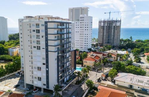 an aerial view of a city with buildings and the ocean at Caribbean Nature Sourrounded Refuge Apartment in Juan Dolio