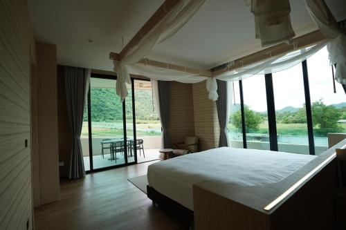 a bedroom with a bed and a large window at Viewpoint Khaoyai Hotel in Mu Si