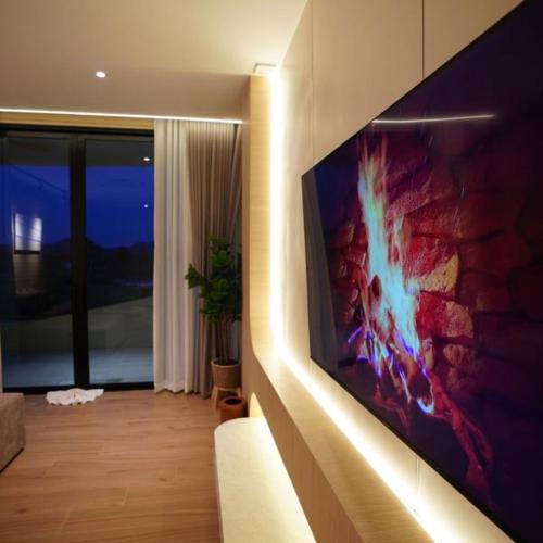 a living room with a flat screen tv on a wall at Viewpoint Khaoyai Hotel in Mu Si