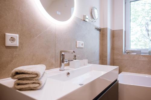 a bathroom with a sink and a mirror at VISAMA, moderne Apartments an der Fulda-Aue in Fulda