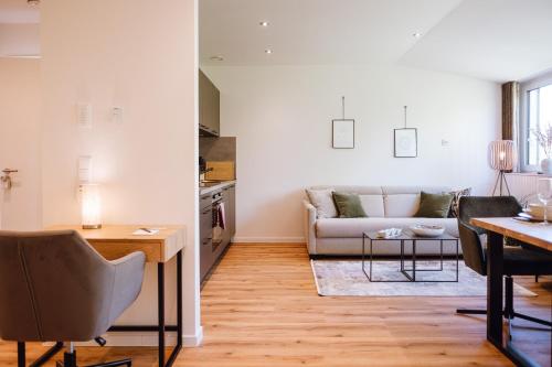 a living room with a couch and a table at VISAMA, moderne Apartments an der Fulda-Aue in Fulda