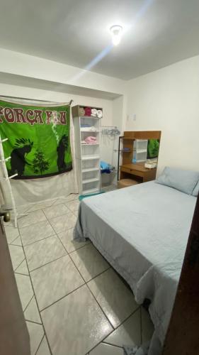 a bedroom with a large bed and a desk at casa km in Rio das Ostras