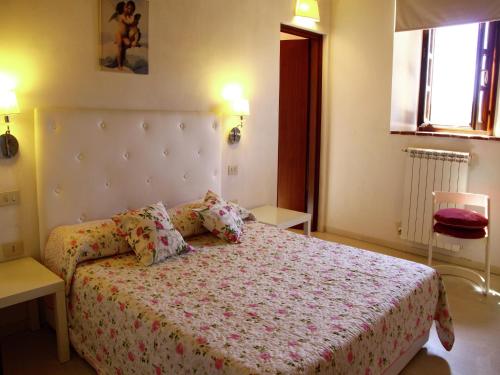 ein Schlafzimmer mit einem Bett mit einer weißen Bettdecke und Kissen in der Unterkunft Idyllic holiday home in Vinci with swimming pool in Vinci