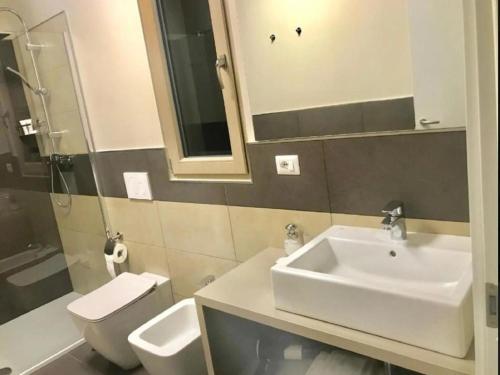 a bathroom with a sink and a toilet and a mirror at Apartment in Iseo with Pool in Cazzago San Martino