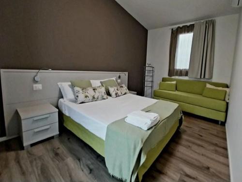 a bedroom with a large bed and a green couch at Apartment in Iseo with Pool in Cazzago San Martino