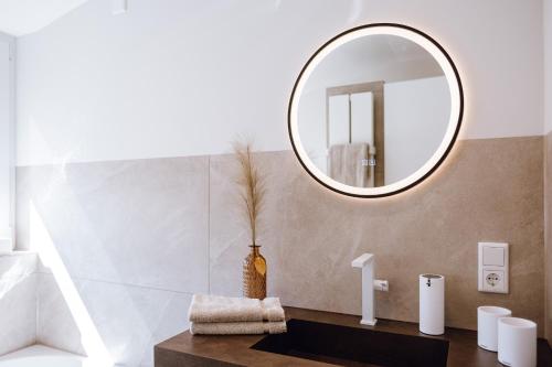 a bathroom with a mirror and a sink at VISAMA, moderne Apartments an der Fulda-Aue in Fulda