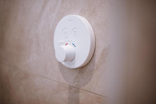 a white object with a face on the wall at VISAMA, moderne Apartments an der Fulda-Aue in Fulda
