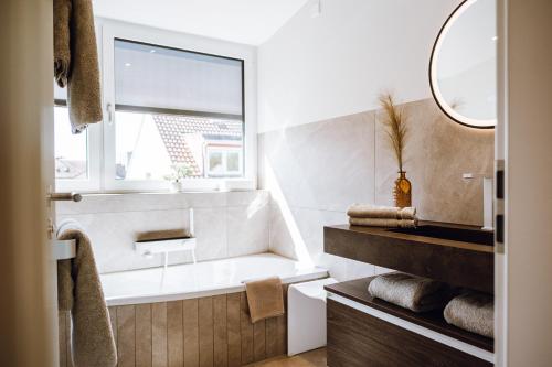 a bathroom with a bath tub and a window at VISAMA, moderne Apartments an der Fulda-Aue in Fulda