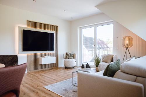 a living room with a couch and a flat screen tv at VISAMA, moderne Apartments an der Fulda-Aue in Fulda