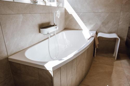 a bathroom with a bath tub with a sink at VISAMA, moderne Apartments an der Fulda-Aue in Fulda
