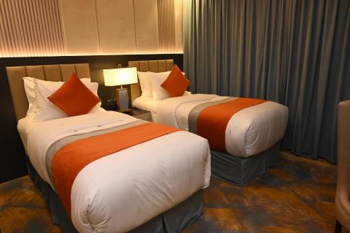 two beds sitting in a hotel room with at فندق امان أبها - المعالي in Abha