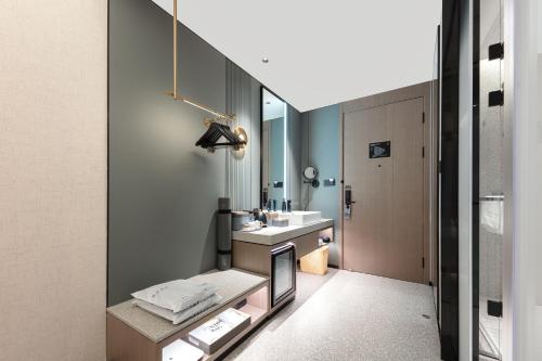 Atour S Hotel Suzhou Jinji Lake Moonlight Pier في سوتشو: حمام مع حوض ومرآة