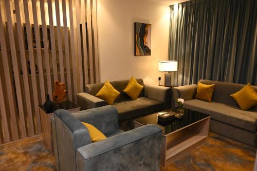 a living room with couches and yellow pillows at فندق امان أبها - المعالي in Abha