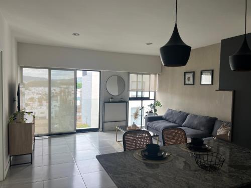 un salon avec un canapé et une table dans l'établissement Acogedor departamento en solares zona real, alberca, gym y terrazas, à Guadalajara