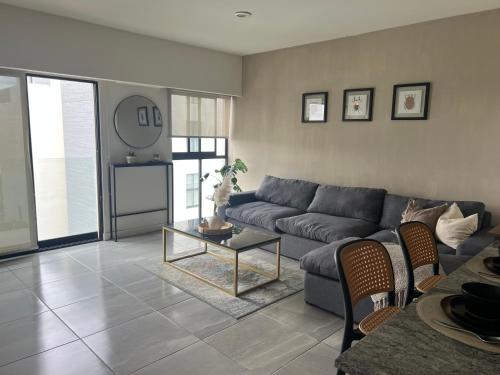 un salon avec un canapé et une table dans l'établissement Acogedor departamento en solares zona real, alberca, gym y terrazas, à Guadalajara