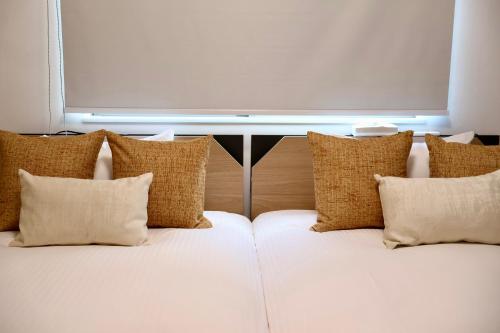 een groep kussens op een bank in een kamer bij New open 岸里玉出 Maison Le Jaune 玉子心斋桥道顿崛电车直达 in Osaka