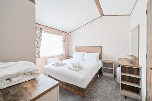 Un dormitorio pequeño con una cama y una ventana. en Wave Whisperers - Hayling Island, en South Hayling