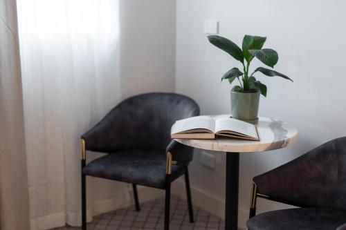 a table with a book and a potted plant on it at Metropole Katoomba in Katoomba