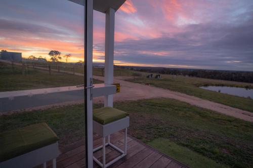 a view of a sunset from the porch of a house at Banjos Cabin Gippsland - Luxury Eco Stay - King Bed, Pond Valley Views, Fireplace in Seaton
