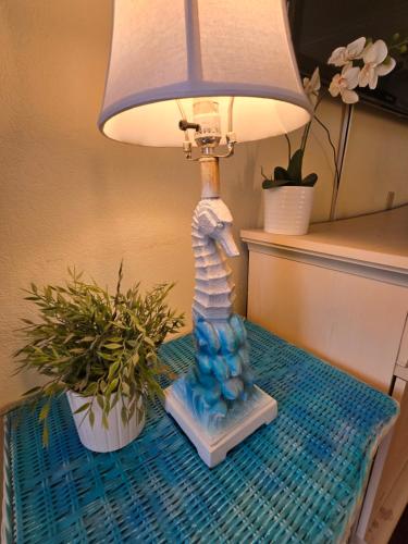 a lamp sitting on a table next to a potted plant at Sunset Cove - Water View in Sarasota