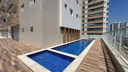 Apartamento Canto do Forte في برايا جراندي: منزل به مسبح على مبنى