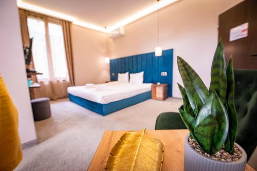a hotel room with a bed and a table with a plant at Вила АРБОРЕТУМ in Teteven