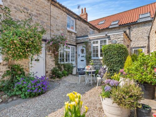 a garden with flowers in front of a house at Mill Cottage in Pickering