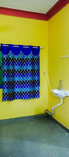 a yellow bathroom with a sink and a window at Sai homestay first floor apartment in Kanchipuram