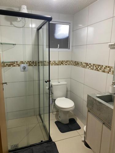 a bathroom with a toilet and a glass shower at Apto Completo com Cozinha Equipada in Valparaíso de Goiás