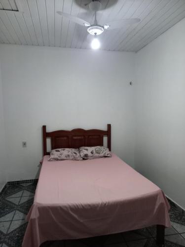 una cama en una habitación con ventilador de techo en Casa Branca, en Belém