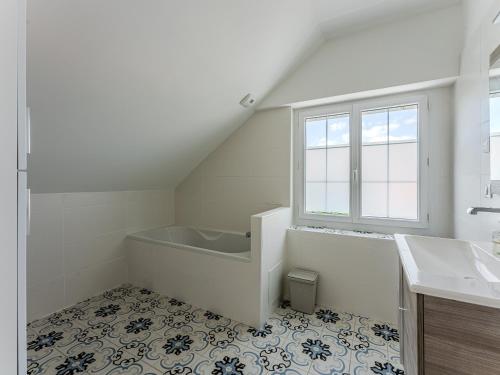 a white bathroom with a tub and a sink at Biscarrosse: Maison 5 chambres avec piscine privée - FR-1-521-258 in Biscarrosse
