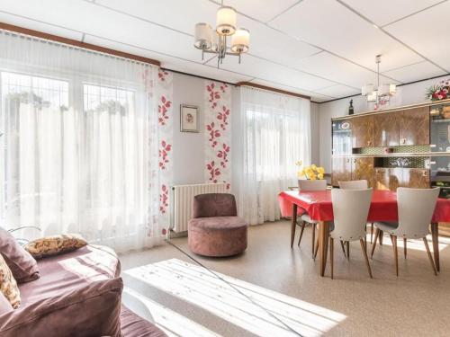 - un salon avec une table et des chaises rouges dans l'établissement Charmant pavillon au calme, idéal pour famille ou amis près des Vosges - FR-1-583-421, à Champagney