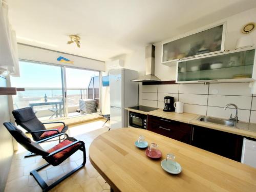 une cuisine avec une table et une cuisine avec vue dans l'établissement Studio moderne climatisé, 2 pers, face à la mer, proche plage et commerces, Canet-en-Roussillon - FR-1-794-133, à Canet