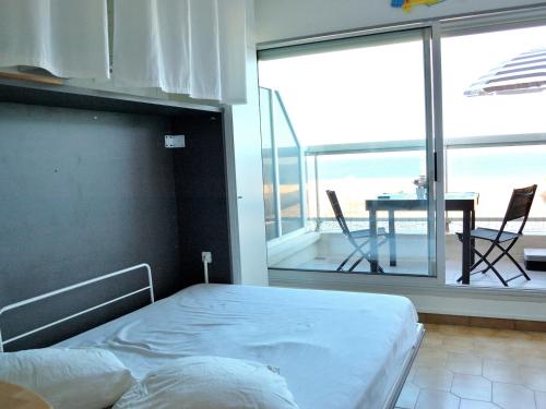 une chambre avec un lit et un balcon avec une table dans l'établissement Studio moderne climatisé, 2 pers, face à la mer, proche plage et commerces, Canet-en-Roussillon - FR-1-794-133, à Canet
