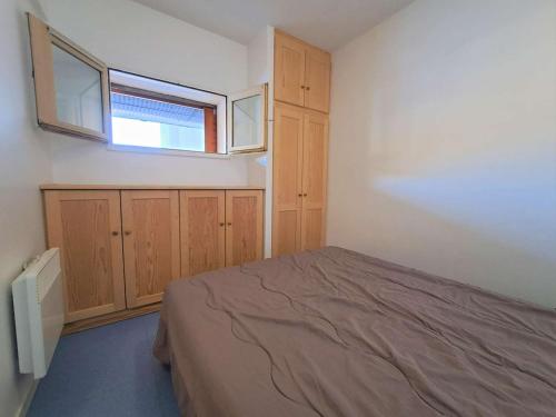 - une chambre avec un lit, une fenêtre et des armoires en bois dans l'établissement Appartement 5 pers à 100m des pistes, parking - FR-1-525-294, à Superdevoluy