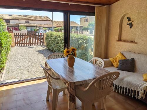 une salle à manger avec une table, des chaises et un canapé dans l'établissement Charmante villa T2 mezzanine avec cour, jardin, véranda, barbecue et parking privé, proche plage et commerces - FR-1-797-2, à Port-la-Nouvelle