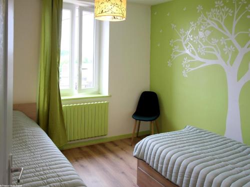 a bedroom with a bed and a tree mural on the wall at Appartement rénové 3 chambres à Luxeuil-les-Bains - FR-1-583-398 in Luxeuil-les-Bains