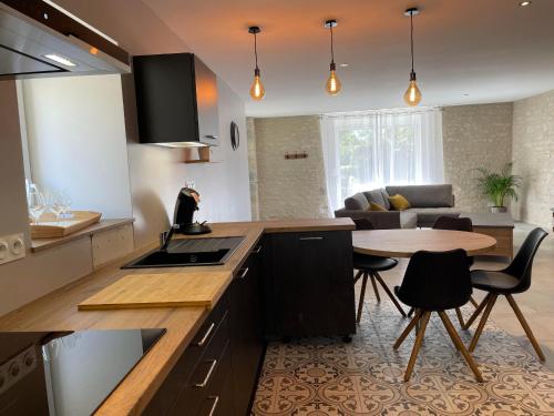 une cuisine avec une table et un salon dans l'établissement Charmant gîte indépendant avec jardin et activités familiales - FR-1-583-415, à Maizières