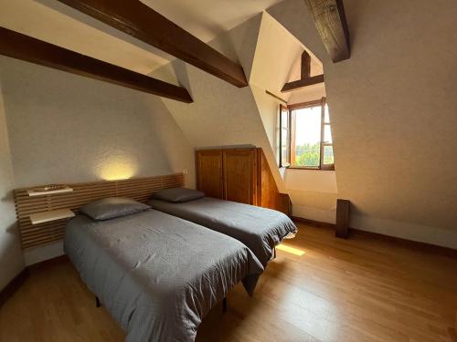 une chambre avec deux lits et une fenêtre dans l'établissement Maison en pierres authentique avec jardin au cœur du Périgord Vert - FR-1-839-5, à Angoisse