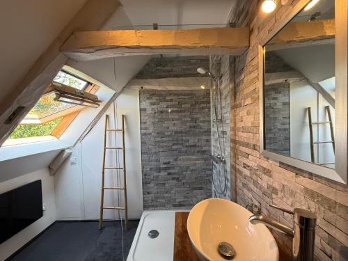 La salle de bains est pourvue d'un lavabo, d'un miroir et d'une échelle. dans l'établissement Maison en pierres authentique avec jardin au cœur du Périgord Vert - FR-1-839-5, à Angoisse