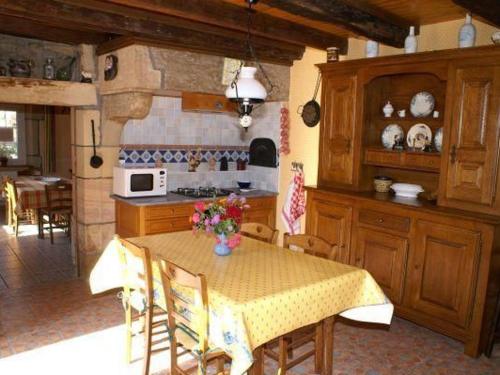 - une cuisine avec une table et des fleurs dans l'établissement Charmant gîte restauré dans un village forestier - FR-1-583-417, à Mailleroncourt-Charette