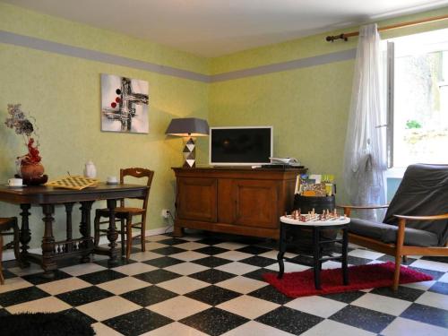 un salon avec une télévision, une table et des chaises dans l'établissement Gîte Les Glycines - Calme avec wifi et animaux admis - FR-1-583-402, à Chargey-lès-Port