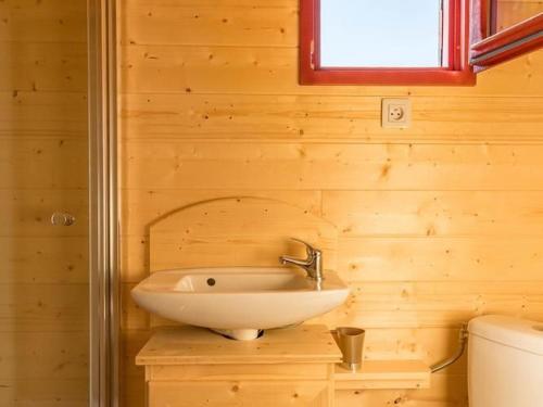 a bathroom with a sink in a wooden wall at Charmante Roulotte avec Vue Vallée de la Saône - FR-1-583-418 in Vy-le-Ferroux