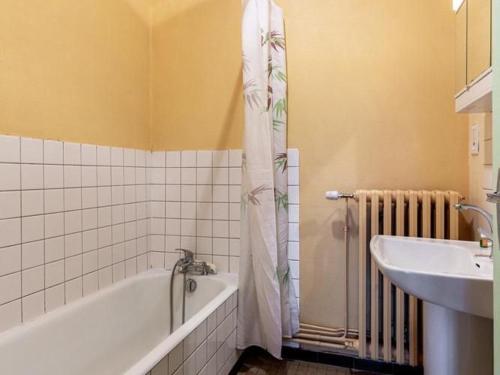 une salle de bain avec une baignoire et un lavabo dans l'établissement Appartement charmant au pied du Plateau des Mille Etangs à Mélisey - FR-1-583-425, à Mélisey